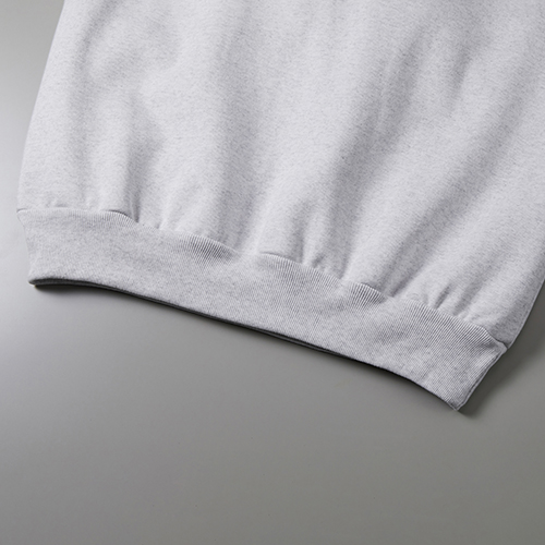 カンガルーポケット仕様、裾口のフロントはステッチを排したミニマルな縫製仕様<br />